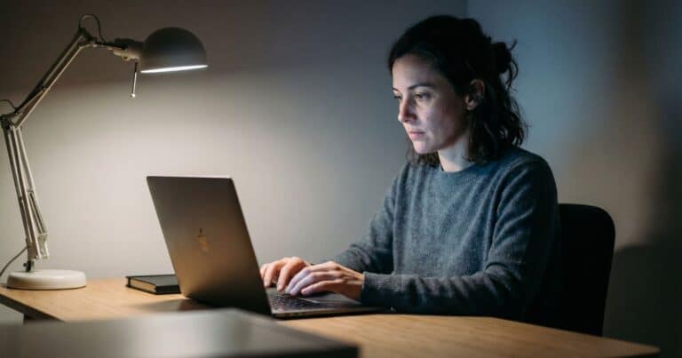 ChatGPT for LinkedIn writer staring at blank laptop screen in night home office, cursor blinking