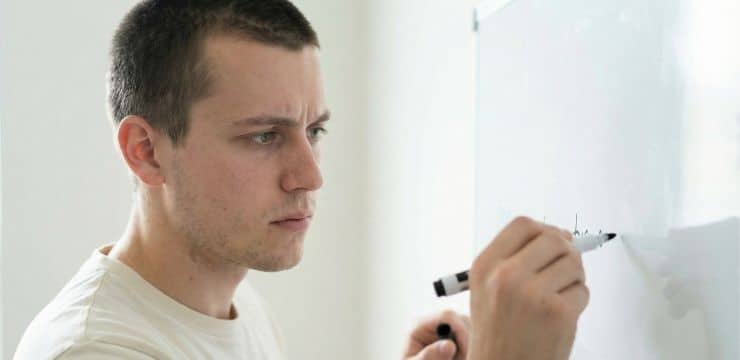 Generative engine optimization strategy, creator writing clear statement on whiteboard for ai visibility in daylight workspace