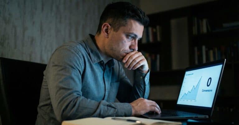 Content marketing traffic but no leads, founder reviewing analytics dashboard at night in home office